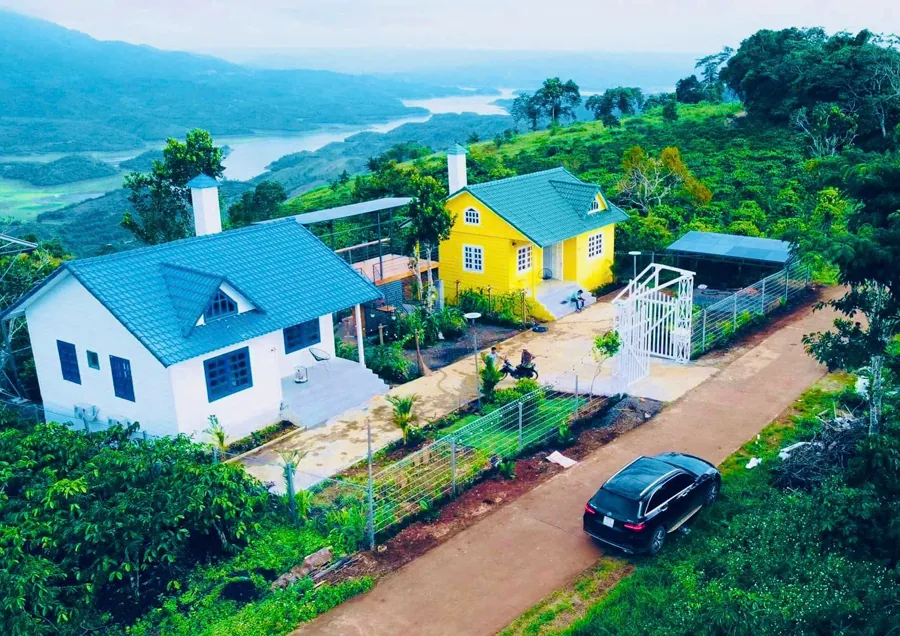 Hai căn nhà nhỏ giữa vườn trên đồi, có lối đất dẫn vào, ở Tà Đùng